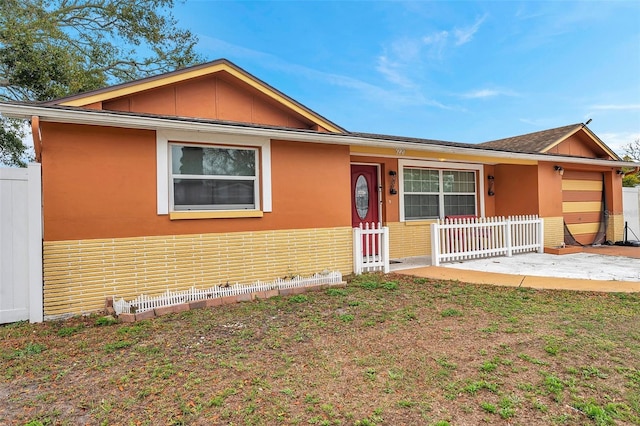 single story home with brick siding, stucco siding, an attached garage, a patio area, and fence