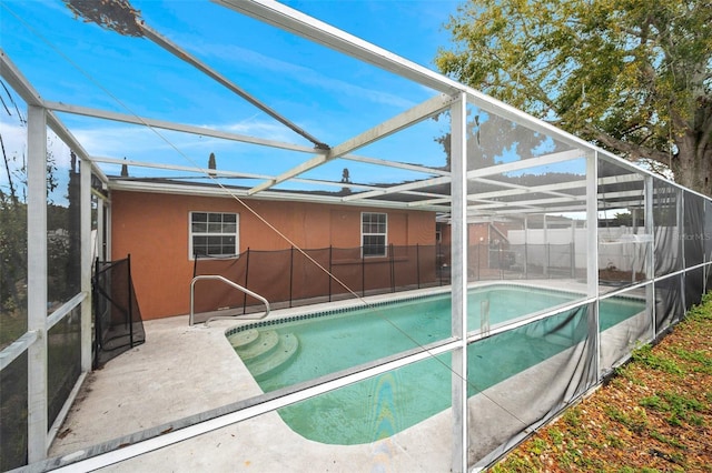 view of pool with glass enclosure, a patio area, and a fenced in pool