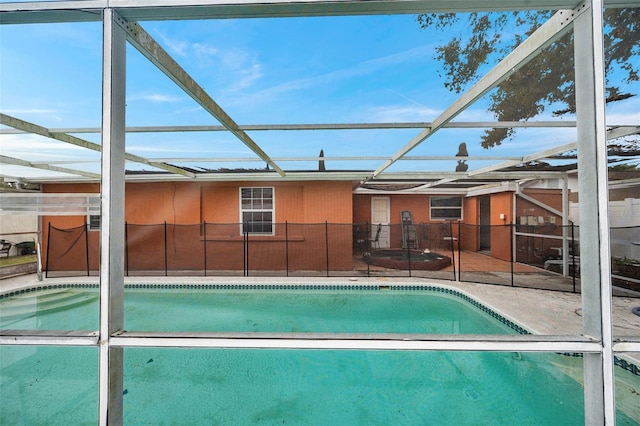 pool with a patio and glass enclosure