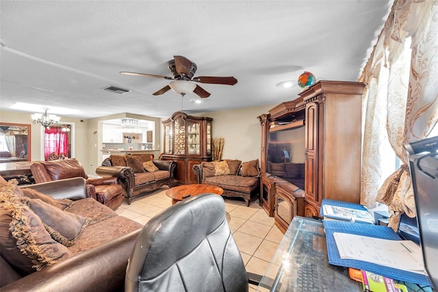 living room with light tile patterned floors, visible vents, a textured ceiling, and ceiling fan with notable chandelier