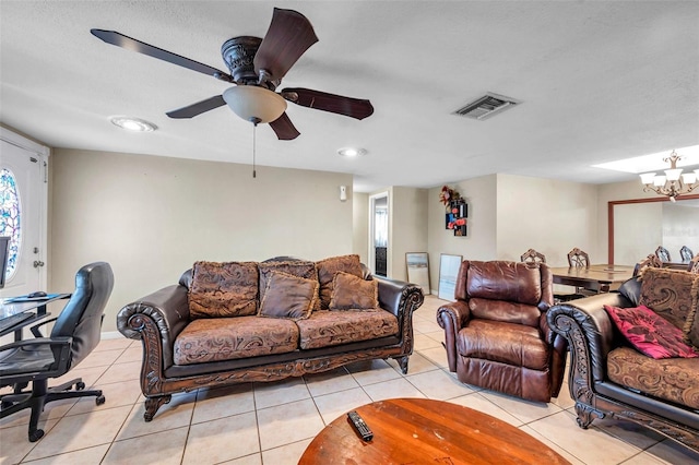 living area featuring ceiling fan with notable chandelier, visible vents, and light tile patterned flooring