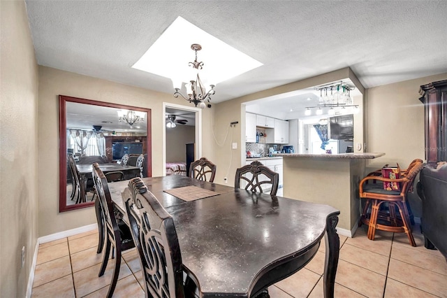 dining room with a healthy amount of sunlight, light tile patterned floors, a chandelier, and a textured ceiling