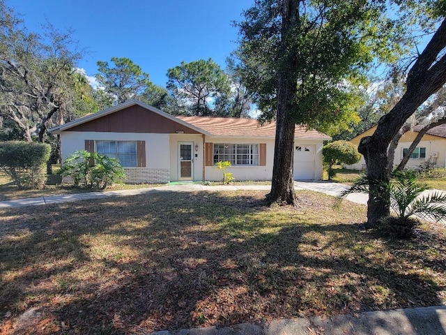 ranch-style house with a garage and a front lawn