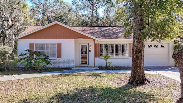 ranch-style house with brick siding, a shingled roof, concrete driveway, a garage, and a front lawn