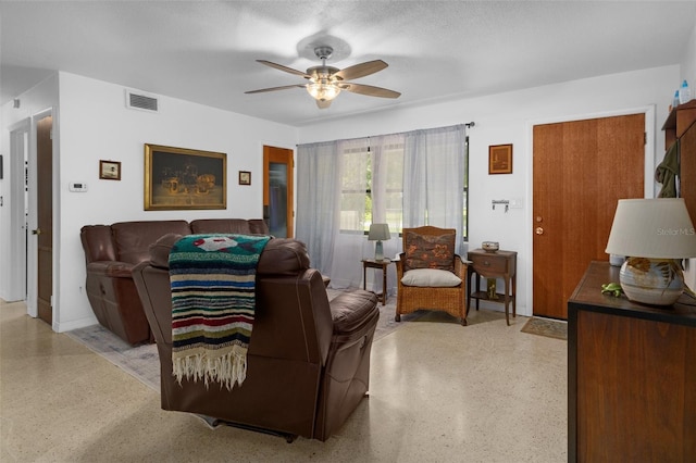 living room featuring a textured ceiling and ceiling fan