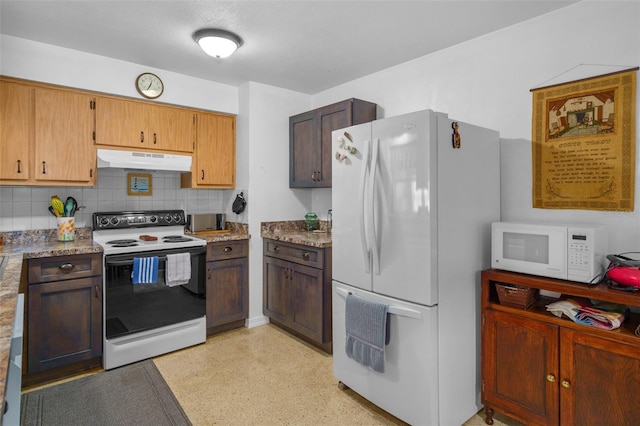 kitchen featuring light stone counters, white appliances, and decorative backsplash