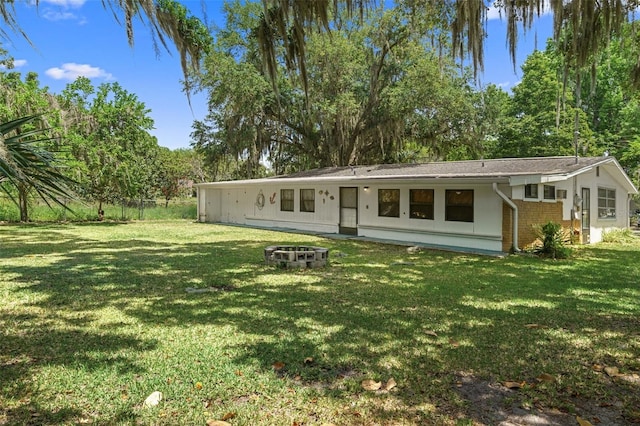 view of front facade featuring a front yard and an outdoor fire pit