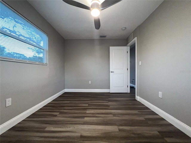 empty room featuring ceiling fan and dark hardwood / wood-style flooring