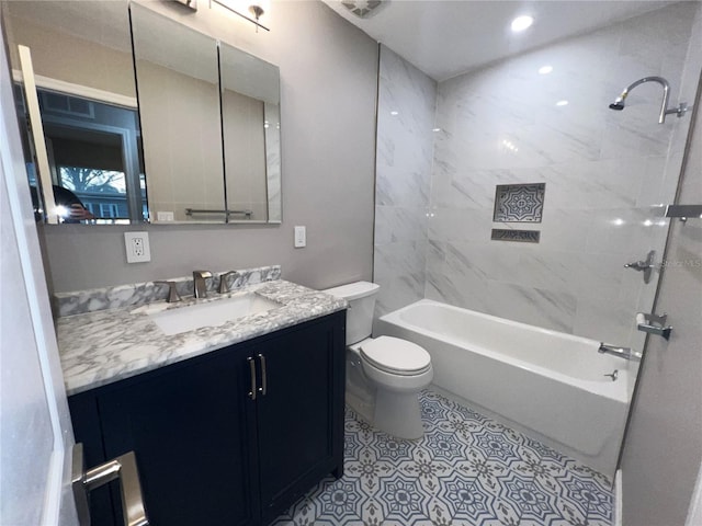 full bathroom featuring vanity, tile patterned flooring, toilet, and tiled shower / bath