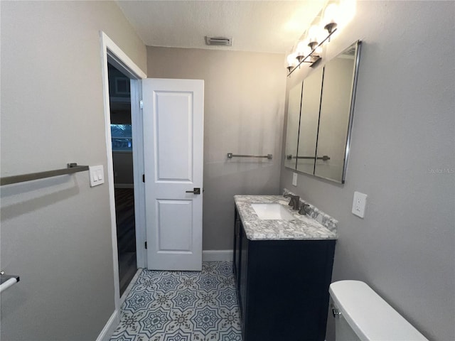 bathroom featuring vanity, toilet, and a textured ceiling