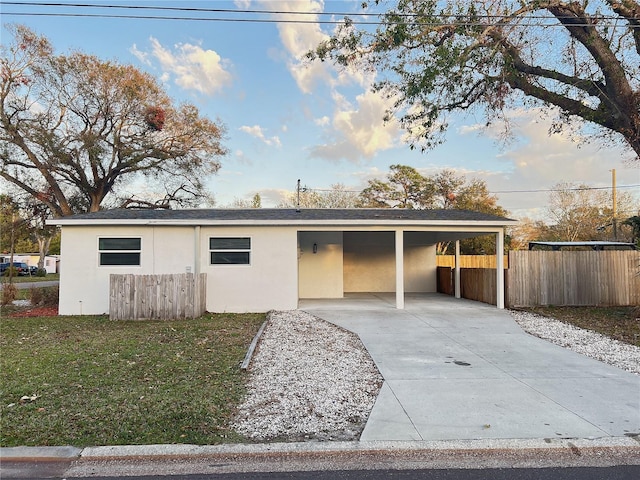 ranch-style house featuring a carport and a front lawn