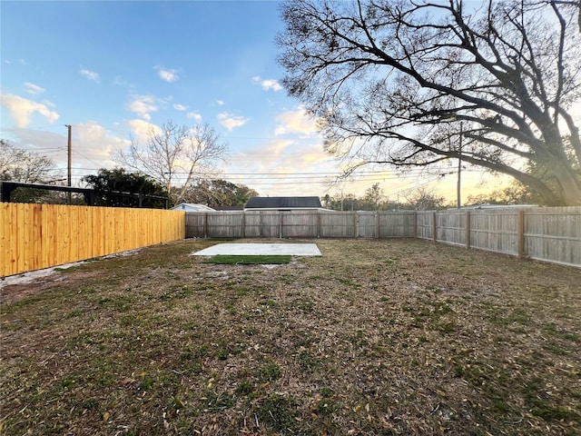 yard at dusk featuring a patio area