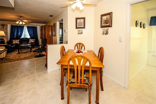 dining space featuring a textured ceiling, ceiling fan, and light tile patterned floors