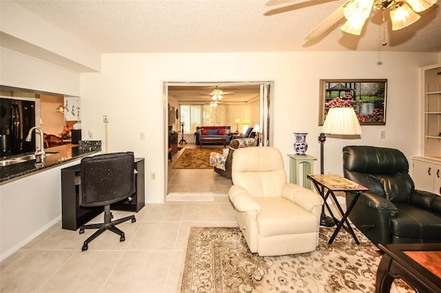 tiled home office featuring ceiling fan, sink, and a textured ceiling