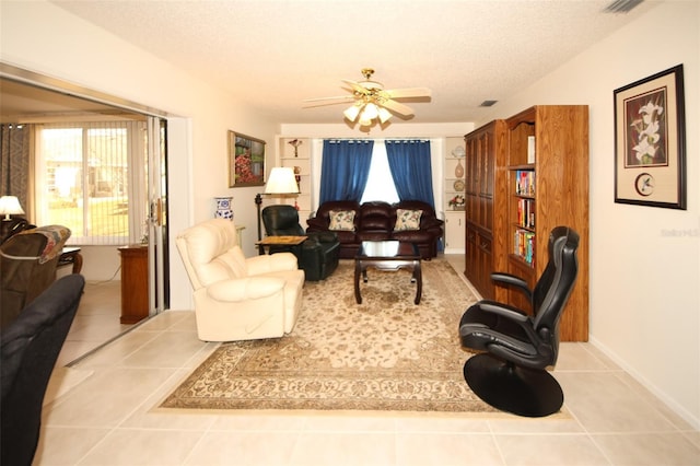 tiled living room featuring ceiling fan and a textured ceiling