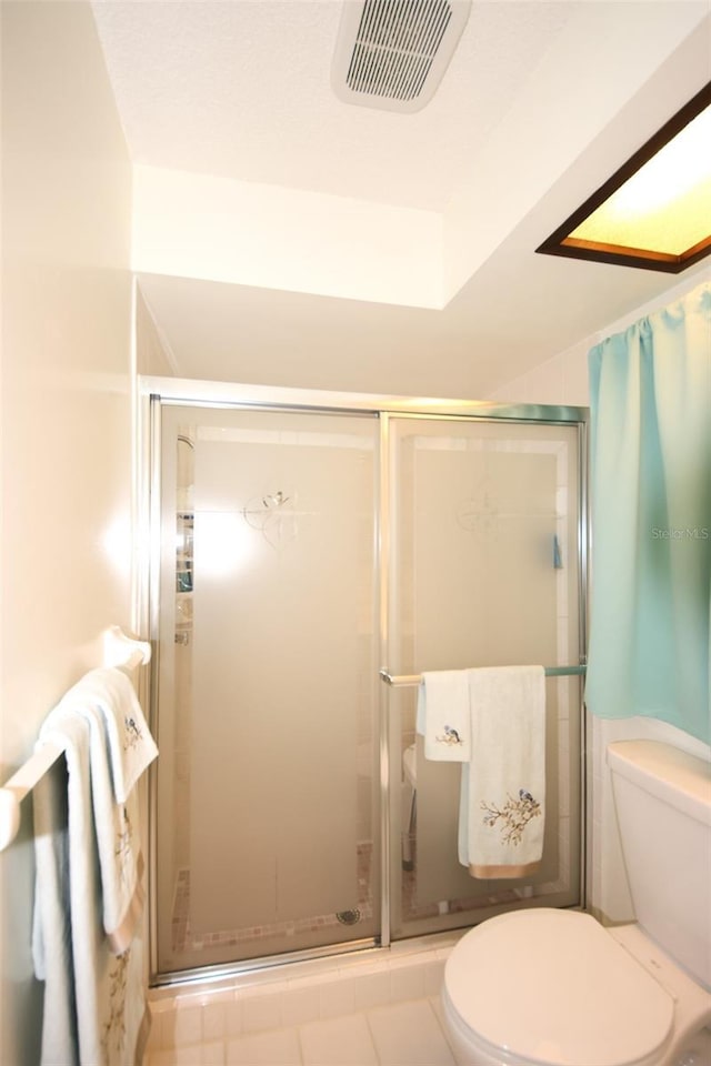 bathroom with an enclosed shower and toilet