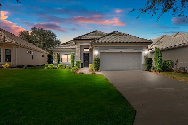 mediterranean / spanish house with a garage and a lawn