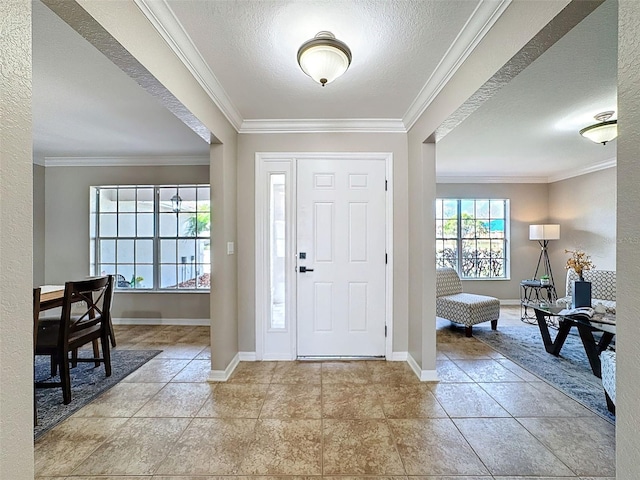 foyer with a textured ceiling and ornamental molding