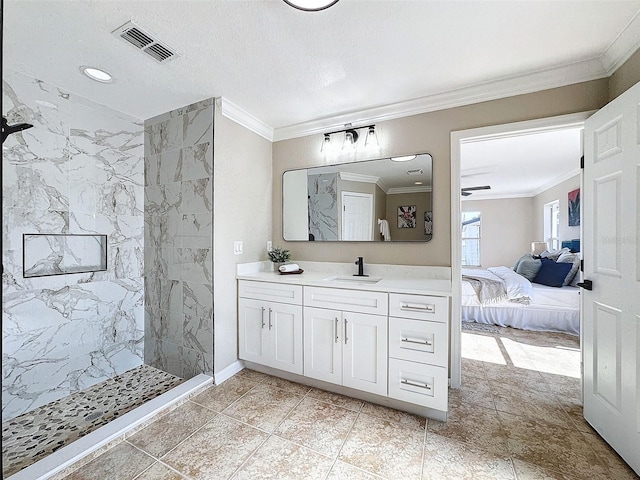 bathroom with vanity, crown molding, and a tile shower