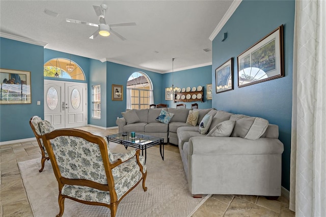 living room with ornamental molding, stone tile flooring, and baseboards