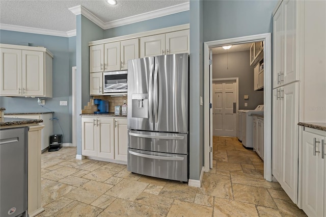 kitchen with baseboards, stainless steel appliances, crown molding, a textured ceiling, and stone tile flooring