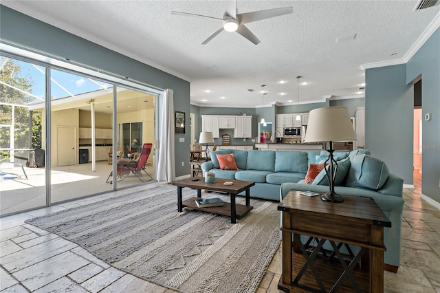 living room with visible vents, baseboards, ornamental molding, stone tile flooring, and a textured ceiling