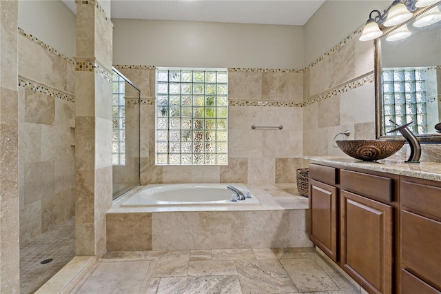 full bathroom with tiled shower, vanity, a bath, and stone tile floors