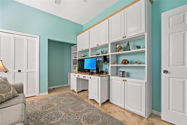 interior space featuring a textured ceiling and baseboards