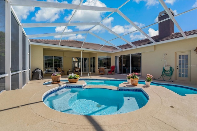 pool with glass enclosure and a patio area