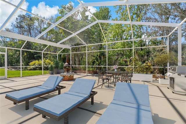 view of patio / terrace featuring glass enclosure and a grill