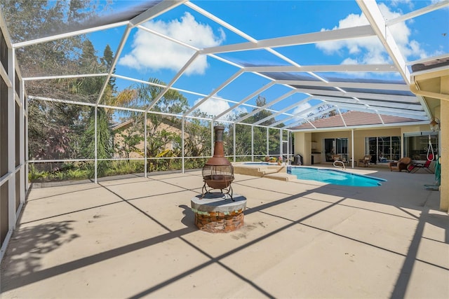 view of swimming pool with glass enclosure, a patio area, and a pool with connected hot tub