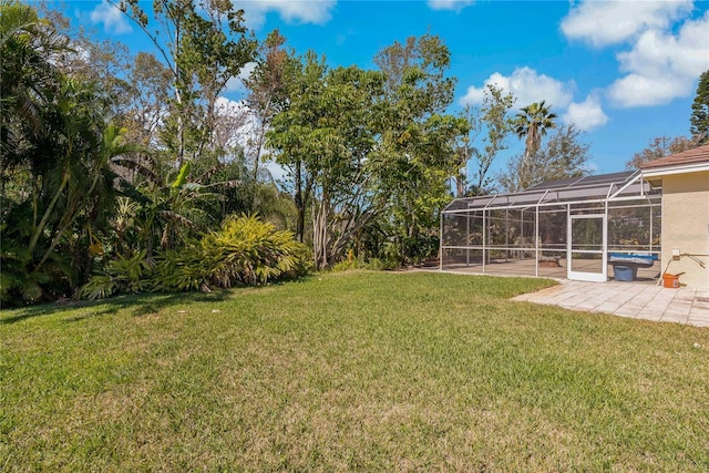 view of yard featuring a lanai, a patio area, and an outdoor pool