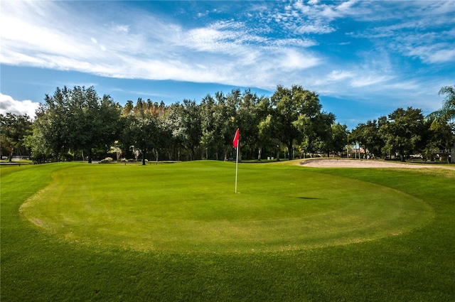 view of community with view of golf course and a lawn