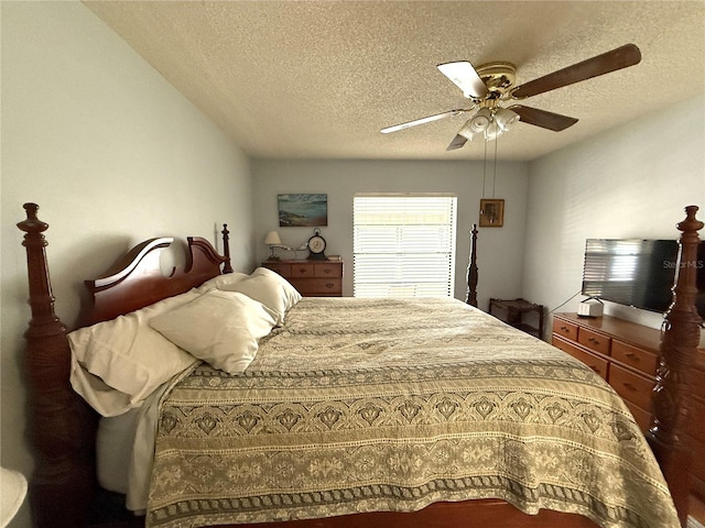 bedroom with ceiling fan and a textured ceiling