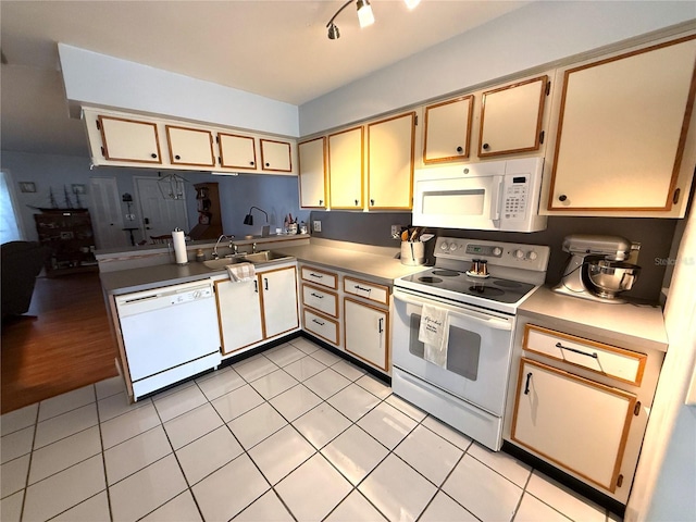 kitchen featuring light tile patterned flooring, sink, and white appliances