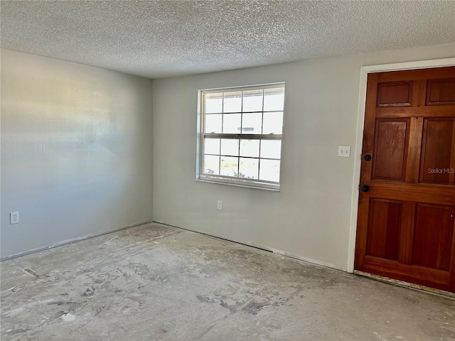 unfurnished room with a textured ceiling