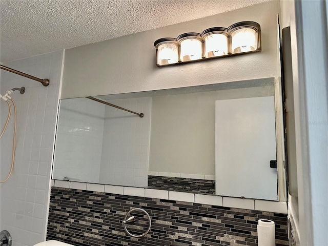 bathroom with a textured ceiling and a tile shower