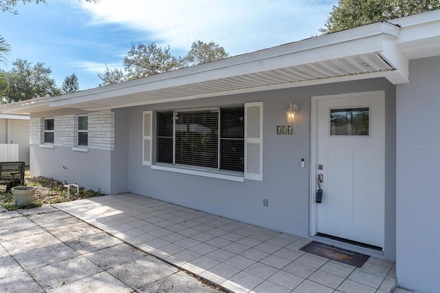 view of exterior entry with a patio area