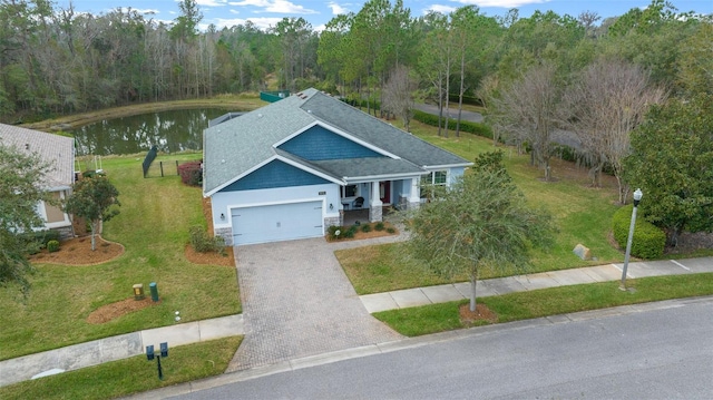 view of front of property featuring a garage, a water view, and a front lawn