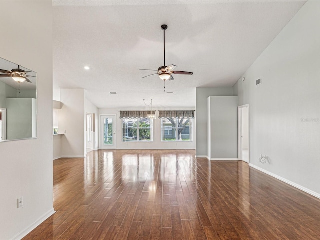 unfurnished living room with dark wood-style floors, visible vents, ceiling fan, and baseboards