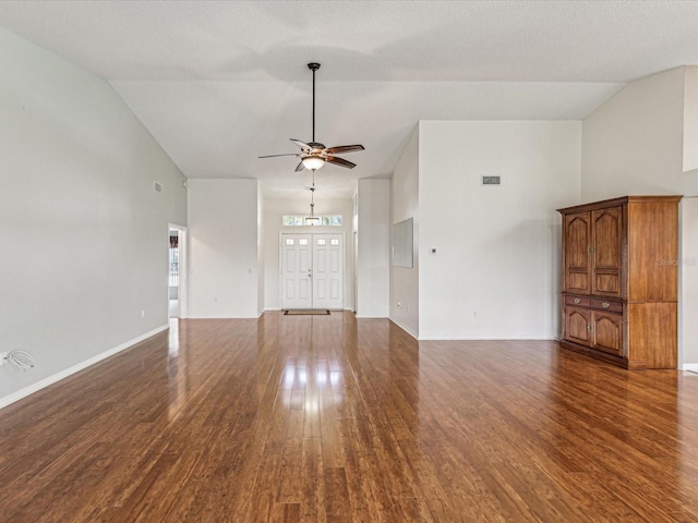 unfurnished living room with ceiling fan, high vaulted ceiling, dark wood finished floors, and baseboards