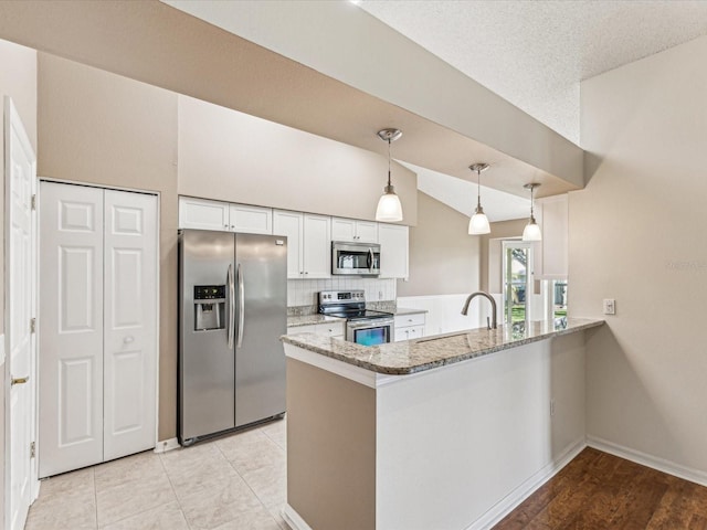 kitchen featuring a peninsula, white cabinetry, stainless steel appliances, and a sink