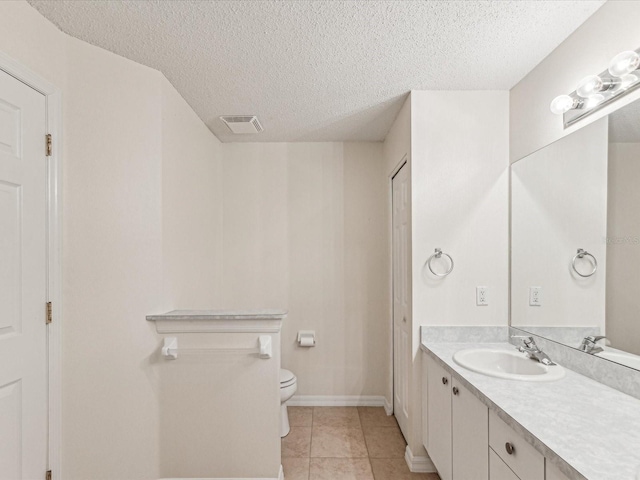 bathroom with a textured ceiling, tile patterned flooring, toilet, vanity, and visible vents