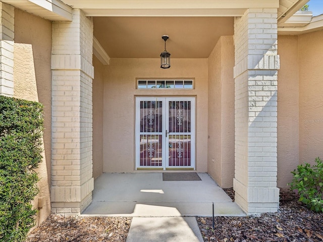 doorway to property with brick siding and stucco siding