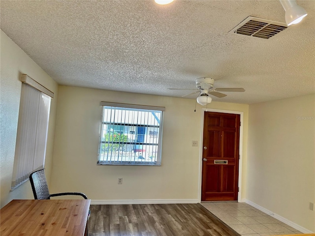 entrance foyer with ceiling fan, wood-type flooring, and a textured ceiling