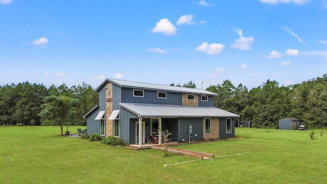 rear view of house featuring covered porch, a lawn, metal roof, a storage shed, and an outdoor structure