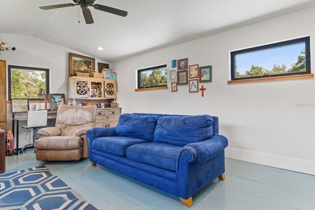 living area featuring a wealth of natural light, baseboards, lofted ceiling, and a ceiling fan