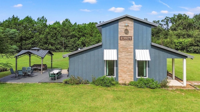 back of property featuring a gazebo and a yard