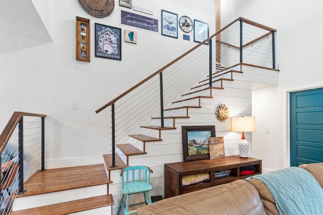 stairway with baseboards and a towering ceiling