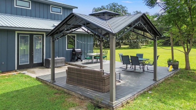 deck with outdoor dining space, area for grilling, a gazebo, french doors, and a lawn